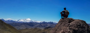A girl sitting on a mountain edge